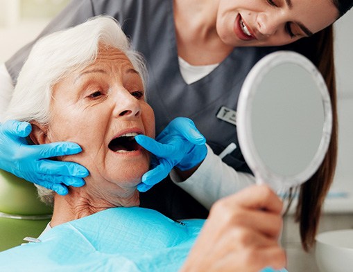 Older woman looking at her dental implants in Modesto
