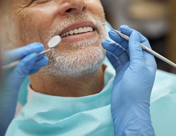 Male patient having his teeth checked as part of dental implant care in Modesto