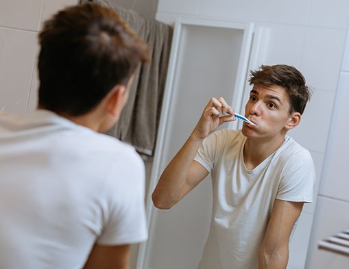 Patient in Modesto smiling while brushing his teeth