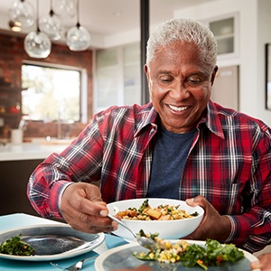 Senior man filling plate at table