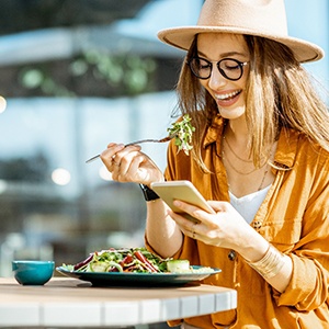 Woman smiling while eating lunch outside